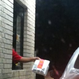a man handing a package to a car a man handing a package to a car