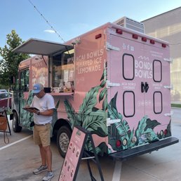 two people standing in front of a food truck