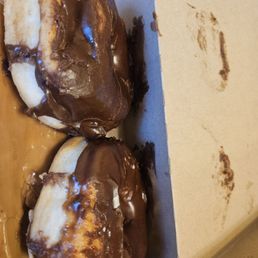 Smushed dented donut. Chocolate pieces missing. Chocolate pieces lifted. Cardboard box tasting what I hope to be a delicious chocolate. Smushed dented donut. Chocolate pieces missing. Chocolate pieces lifted. Cardboard box tasting what I hope to be a delicious chocolate.