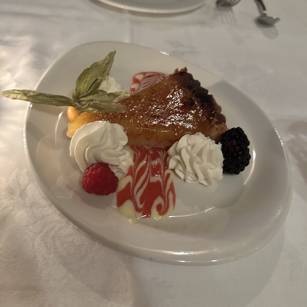 a piece of pie with whipped cream and raspberries