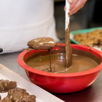 Old Market Candy Shop - a person dipping chocolate into a bowl - Candy Stores Near Me - Omaha, Nebraska Old Market Candy Shop - a person dipping chocolate into a bowl - Candy Stores Near Me - Omaha, Nebraska