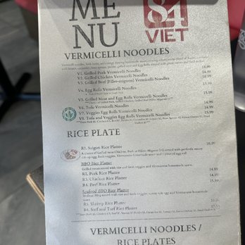 84 Viet - Menu 4/10/2025 - A printed menu from a Vietnamese restaurant displays various vermicelli noodle dishes and rice plates. The menu includes items such as grilled pork, chicken, beef, egg rolls, and seafood options, with prices ranging from approximately $14.99 to $16.99. It features sections for vermicelli noodles and rice plates, with detailed descriptions of each dish. The menu is printed on white paper with black text and some small decorative icons. - Vietnamese Near Me - Berkeley, California