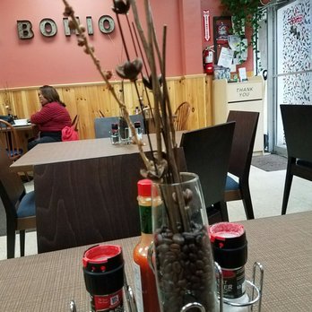 El Bohio Restaurant - a table with a vase of flowers and condiments - Spanish Near Me - Fitchburg, Massachusetts
