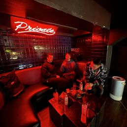 a group of people sitting on a couch in a dimly lit room a group of people sitting on a couch in a dimly lit room