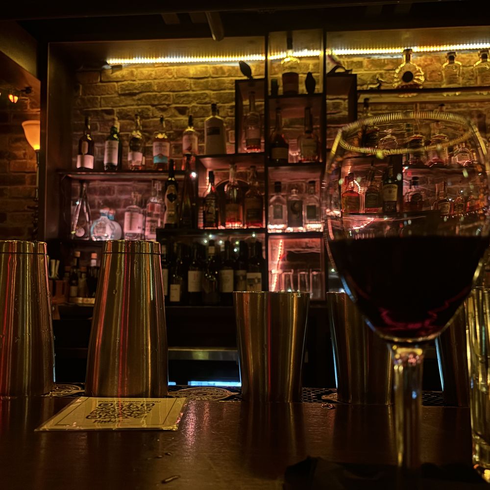 O' Be Joyful - A made up drink in the foreground with a shot of the backlit bar in the background - Burgers Near Me - Franklin, Tennessee O' Be Joyful - A made up drink in the foreground with a shot of the backlit bar in the background - Burgers Near Me - Franklin, Tennessee