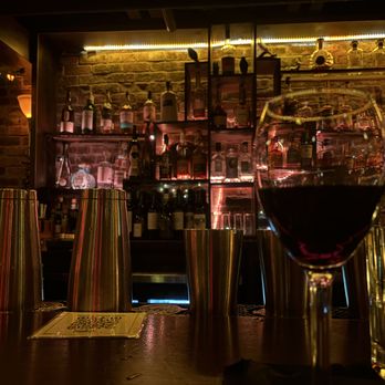 O' Be Joyful - A made up drink in the foreground with a shot of the backlit bar in the background - Burgers Near Me - Franklin, Tennessee