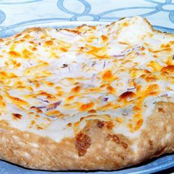 Pierogie pizza. Mashed potatoes, garlic sauce, onions, cheddar, mozzarella, and provolone cheese.