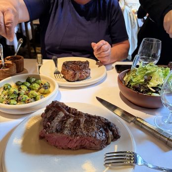 Don Julio - Perfectly grilled monster porterhouse (foreground), baby Brussels sprouts, salad greens, ribeye. - Steakhouses Near Me - Buenos Aires, C
