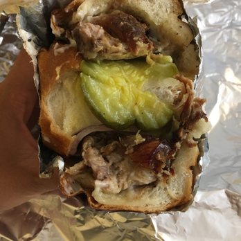 El Dorado - a hand holding a sandwich with pickles - Spanish Near Me - Staten Island, New York El Dorado - a hand holding a sandwich with pickles - Spanish Near Me - Staten Island, New York