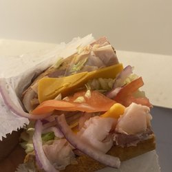 Hollywood Deli - Ham and roast beef sandwich with cheddar, lettuce, tomatoes, and onions.