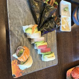 AYCE sushi - salmon avocado hand rolls and a rainbow roll.