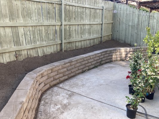 Patio Bed Makeover - This garden wall had a weeded hill behind it and wasn't back filled. A blend of native soil and compost was added to raise the level to about 6" below the top of the wall. The amazing homeowners wanted to have this prepped so they could start the own flower garden and wood mulch plant bed. Patio Bed Makeover - This garden wall had a weeded hill behind it and wasn't back filled. A blend of native soil and compost was added to raise the level to about 6" below the top of the wall. The amazing homeowners wanted to have this prepped so they could start the own flower garden and wood mulch plant bed.