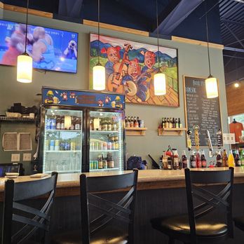 Three Li'l Pigs Barbeque - The Bar of the restaurant with an artwork of Pigs playing musical instruments on the wall above. - Barbeque Near Me - Daleville, Virginia