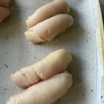 Mikuni - Hamachi nigiri - Three hamachi nigiri sushi pieces with slices of yellowtail fish on rice, served on a white speckled plate. - Japanese Near Me - Davis, California