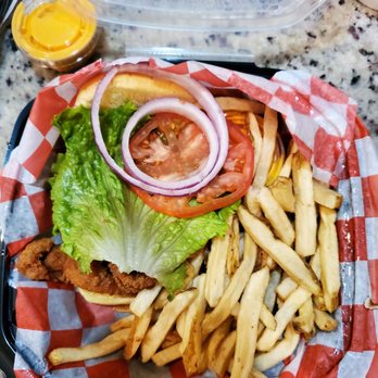 The Crab Shack Crofton - Catfish sandwich w/lettuce, tomato, onion, slaw. Fries and a tangy sauce (orange container behind burger) - Seafood Near Me - Crofton, Maryland The Crab Shack Crofton - Catfish sandwich w/lettuce, tomato, onion, slaw. Fries and a tangy sauce (orange container behind burger) - Seafood Near Me - Crofton, Maryland