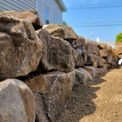TruScape - Crafted with care, this natural stone wall adds both durability and rustic charm to your landscape. TruScape--building with nature in mind.
