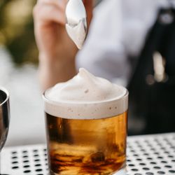 A groom favorite black peppercorn old fashioned topped with Guinness air, served at weddings in Los Angeles.