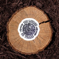 Ecomulch's new 20th anniversary sticker on a wood round on some mulch.