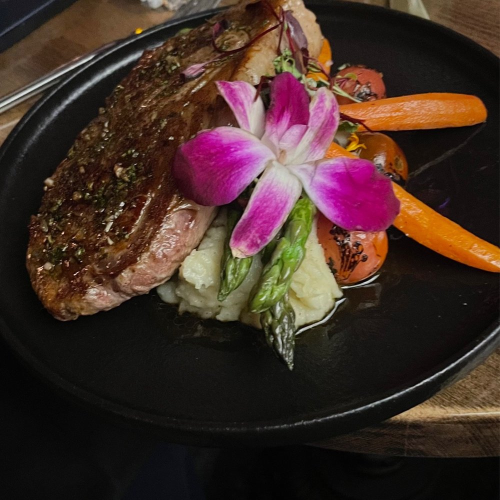 The Bearded Barber - a steak and vegetables on a black plate - Speakeasies Near Me - New River, Arizona The Bearded Barber - a steak and vegetables on a black plate - Speakeasies Near Me - New River, Arizona