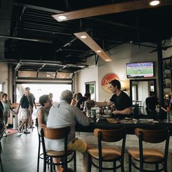A full house at Ava's Rehoboth, with the garage door open to the street and guests filling the dining room and bar.