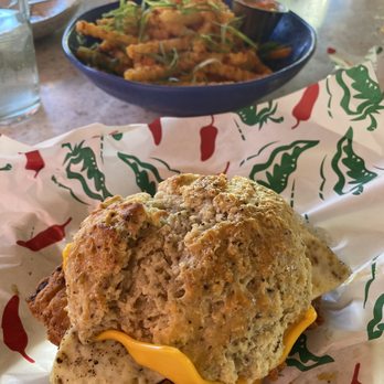 The Toasted Coconut - Honey Butter Biscuits with chicken & fried egg. Fries in the background - New American Near Me - Houston, Texas The Toasted Coconut - Honey Butter Biscuits with chicken & fried egg. Fries in the background - New American Near Me - Houston, Texas