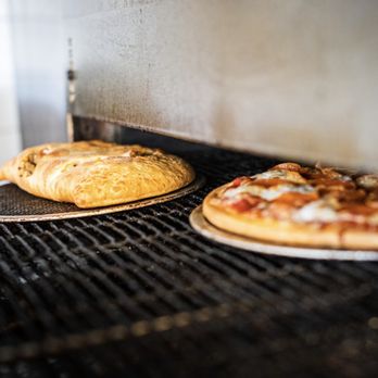 Crust Pizza - two pizzas cooking on a grill - Pizza Near Me - Richmond, Texas Crust Pizza - two pizzas cooking on a grill - Pizza Near Me - Richmond, Texas