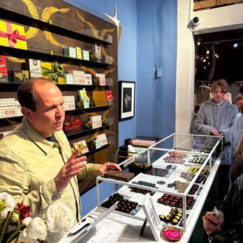 Chocolate + Cashmere - a man standing at a counter in a chocolate shop - Men's Clothing Near Me - Santa Fe, New Mexico