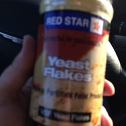 a hand holding a bottle of red star yeast hakes