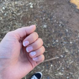 French tip gel nails with glitter and flower detail.