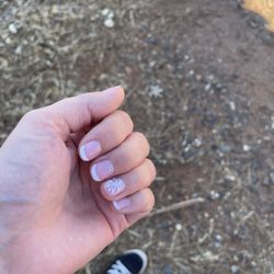 Paradise Nail and Spa - French tip gel nails with glitter and flower detail.