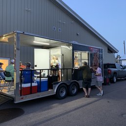 a man and a woman standing in front of a food truck