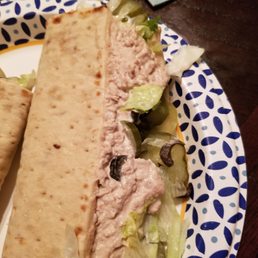 a sandwich on a plate with lettuce and olives a sandwich on a plate with lettuce and olives