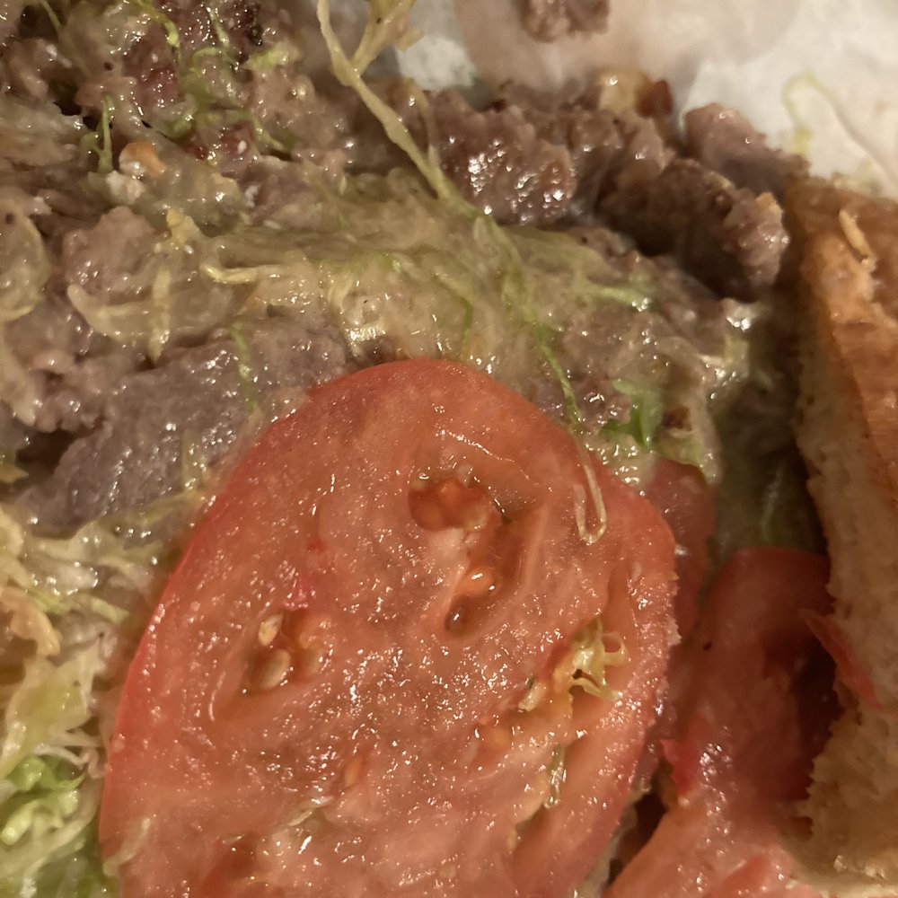 a closeup of a burger with a tomato and lettuce a closeup of a burger with a tomato and lettuce