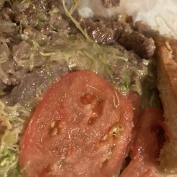 a closeup of a burger with a tomato and lettuce a closeup of a burger with a tomato and lettuce