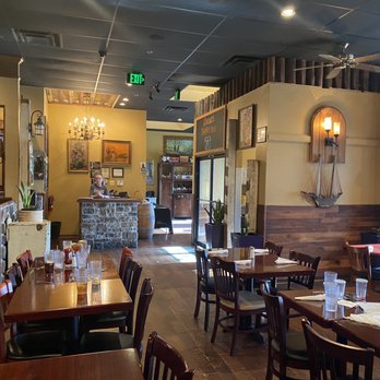 Oscar's Alehouse - Front dining area/entrance, - The image shows the interior of Oscar's Alehouse, featuring multiple dining tables with glasses and napkins, wall decor, and a bar area in the background. - New American Near Me - Eldersburg, Maryland