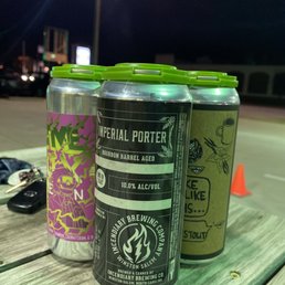three cans of beer on a picnic table three cans of beer on a picnic table