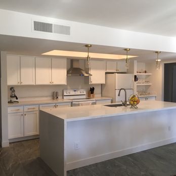 White Quartz Waterfall Countertop With White Shaker Kitchen