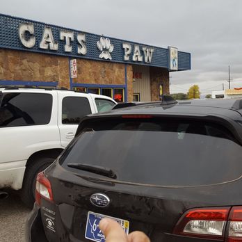 Cat's Paw - a parking lot with cars parked in front of a cat's paw - Bars Near Me - Bozeman, Montana