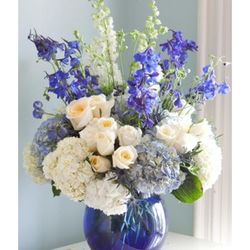 Gratitude Florals & Gifts - Blue Skies Medley. An exquisite mix of roses, hydrangea's, blue delphinium, white snapdragons beautifully hand arranged by our professionals