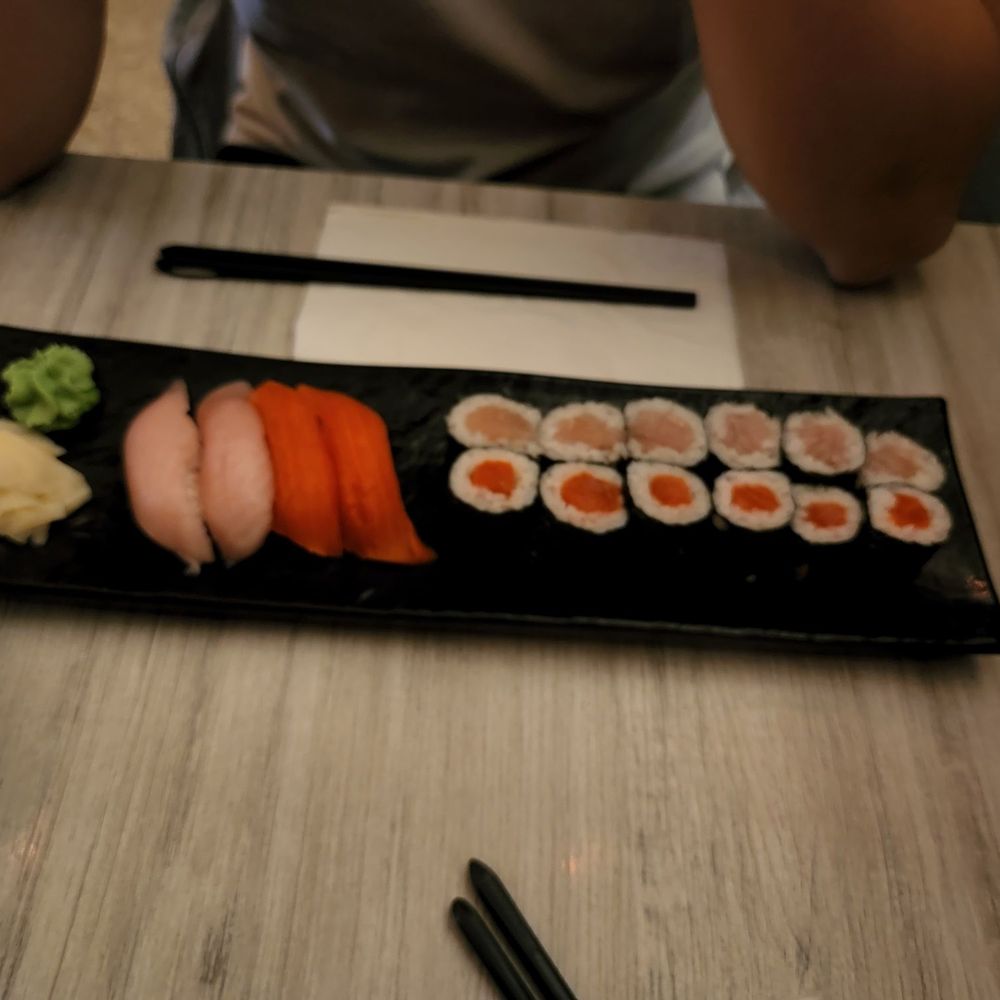 O Sushi - a person sitting at a table with a plate of sushi - Sushi Bars Near Me - Vancouver, British Columbia O Sushi - a person sitting at a table with a plate of sushi - Sushi Bars Near Me - Vancouver, British Columbia