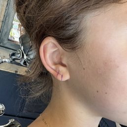 Mapping her ear with a marker to make sure the second piercing is in alignment with her ear fold and first piercing. Really impressive.