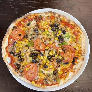 MOD Pizza - a pizza on a plate on a table - Pizza Near Me - Glen Mills, Pennsylvania