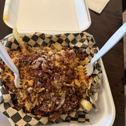 Chili cheese fries with bacon bits and Parmesan