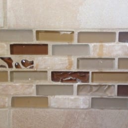 The grout going completely over the glass tiles. They said it's supposed to be that way....argh