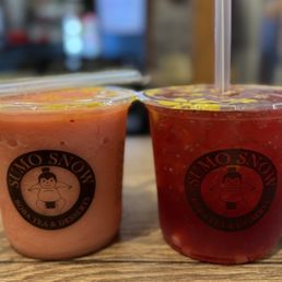 Sunrise and Ha Long Bay - Two cups of fruit drinks from Sumo Snow Express, one pink and one red, are placed on a wooden table with a blurred background.