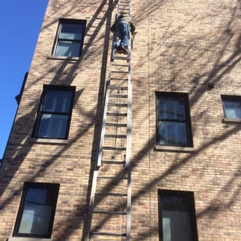 TMC Builders - a man on a ladder climbing up a building - General Contractors Near Me - Chicago, Illinois TMC Builders - a man on a ladder climbing up a building - General Contractors Near Me - Chicago, Illinois