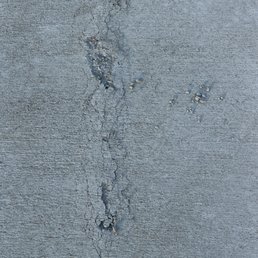 Driveway cracks, severe spalling and uneven slabs.