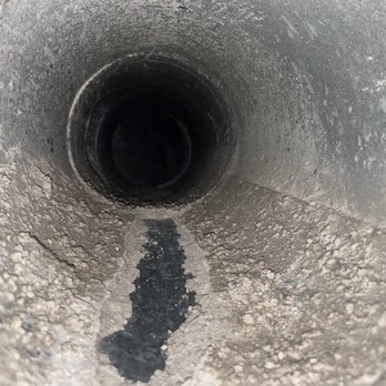 Pure Air - Dmitrii brushed in the middle (where the metal shines through) to show how big of a layer of construction dust fossilized within our duct - Air Duct Cleaning Near Me - El Segundo, California