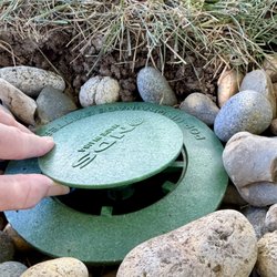 A3 in 1 Irrigation Specialist - Top lifts up when water comes out. The rocks are to prevent the soil from washing away around the collar until the new grass grows strong.