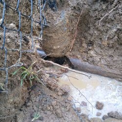 Rainwater Roofing and Construction - Post with concrete going through cast iron septic drain